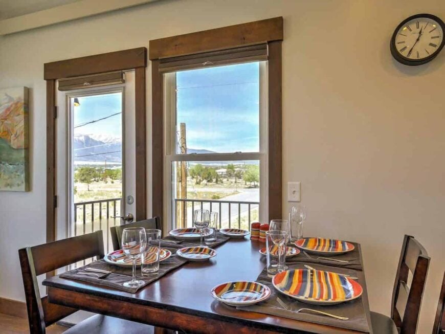 The dining area has a wooden dining set and a glazed door that opens to a balcony.