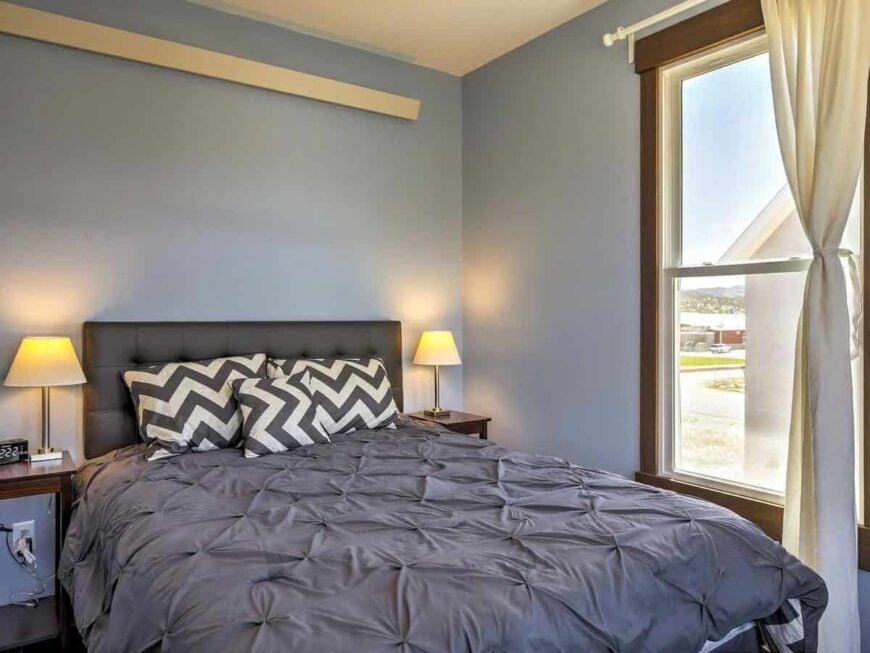 Black chevron pillows accentuate the tufted bed.