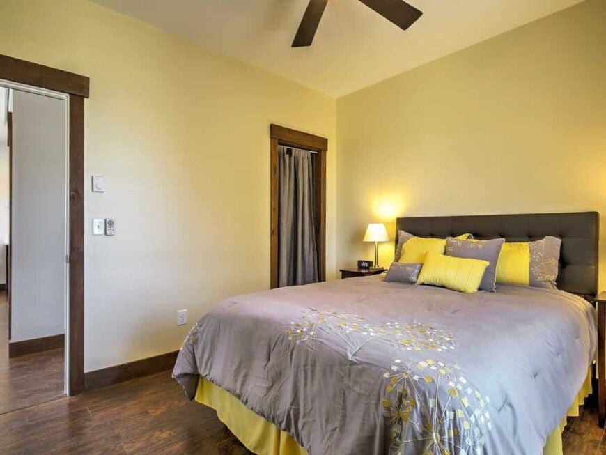 Second bedroom with hardwood flooring and beige walls.