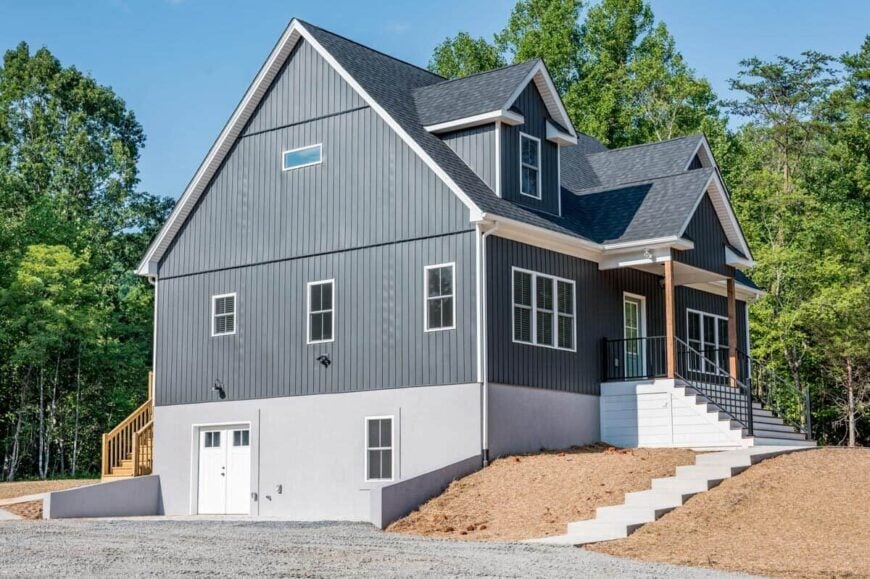 Left exterior view showcasing the blue siding and a walkout basement enclosed in white double doors.