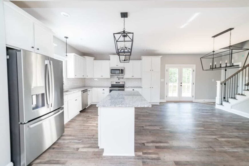 Across the kitchen is the dining space with a linear chandelier.