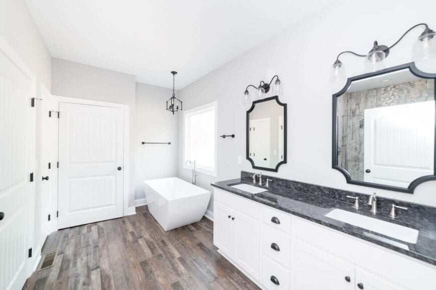 The primary bathroom offers a freestanding tub and a dual sink vanity paired with decorative mirrors.