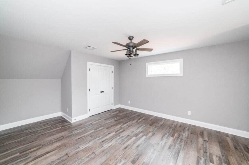This bedroom has a hardwood floor, a built-in closet, and a ceiling fan.