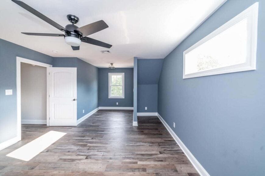 The third bedroom features grayish blue walls lined with white base moldings.