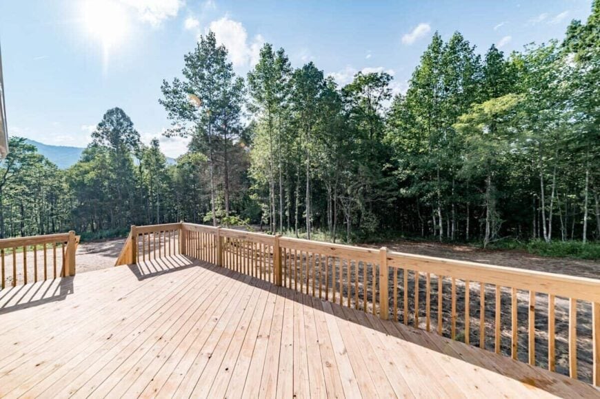 The sun deck is bordered with wooden railings overlooking the surrounding landscape.
