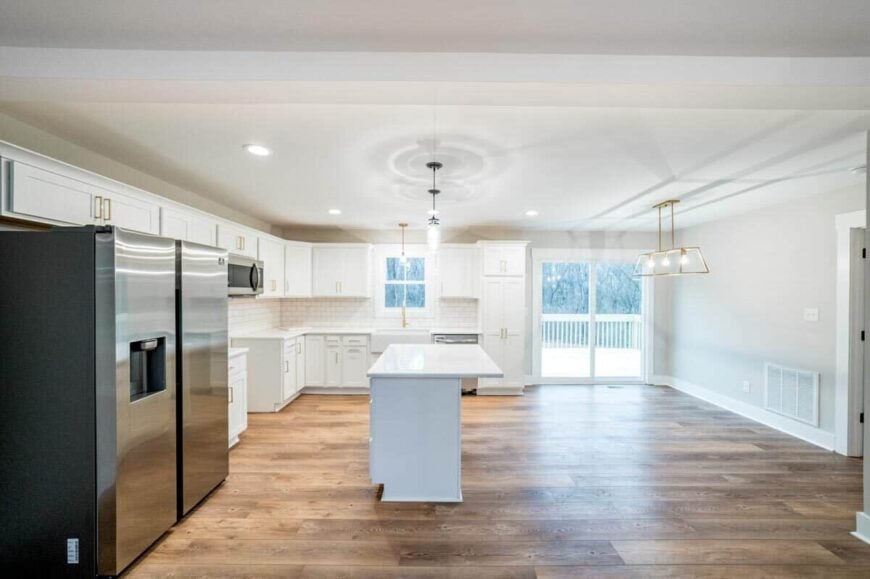 Brass and iron pendants along with recessed ceiling lights brighten the eat-in kitchen.