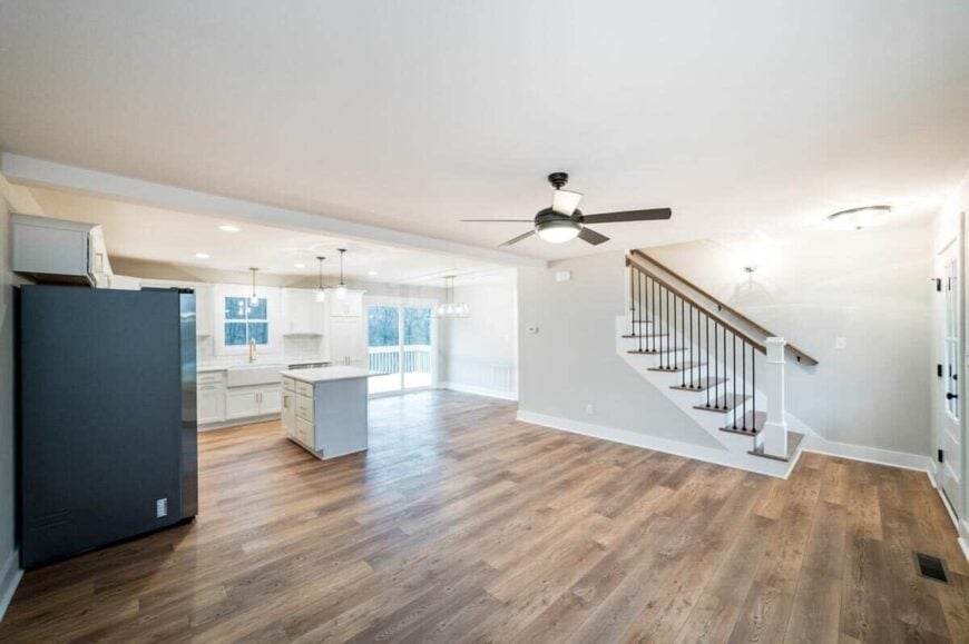 An open layout view of the family room and eat-in kitchen separated by a structural beam.