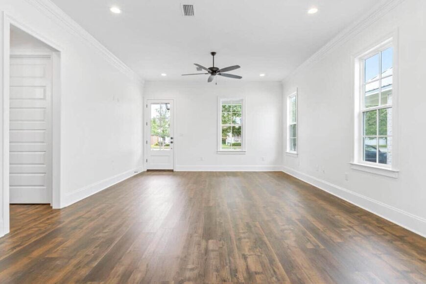 The living room has a wrought iron fan and plenty of windows that enhance the light and airy feel inside.