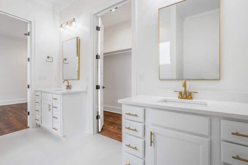 Primary bathroom with his and her sink vanities flanking the walk-in closet.