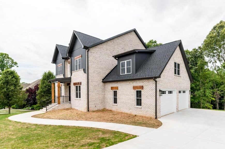 Front-right exterior view with a side-loading double garage complemented with a concrete driveway.