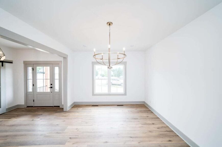 Formal dining room with a large open doorway and a window that looks out the front yard.