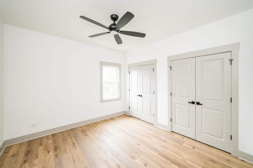 This bedroom features two walk-in closets enclosed in white double doors.