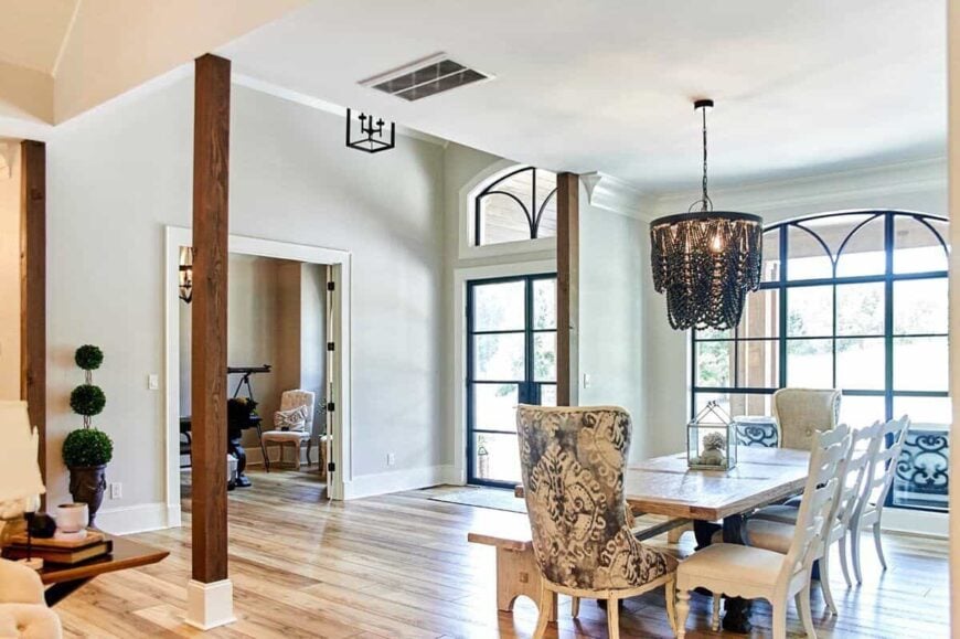 Formal dining room with a black beaded chandelier and a wooden dining table paired with mismatched seats.
