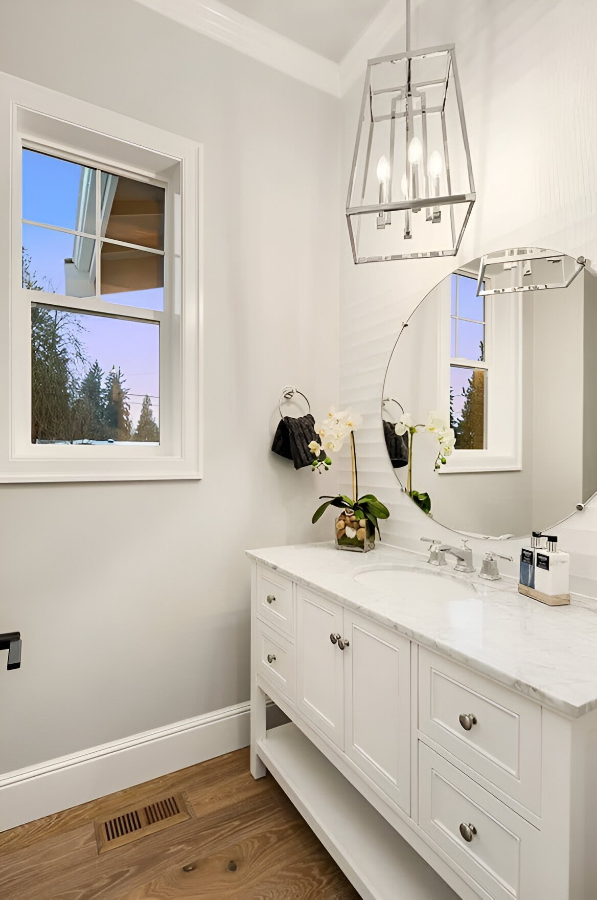 A chrome pendant light hanging from the gray ceiling illuminates the powder room.