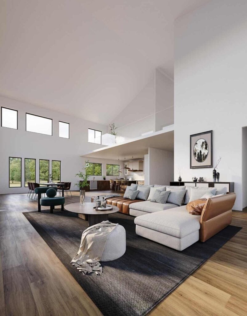 Great room with an L-shaped sofa and an oval coffee table under the two-story ceiling.