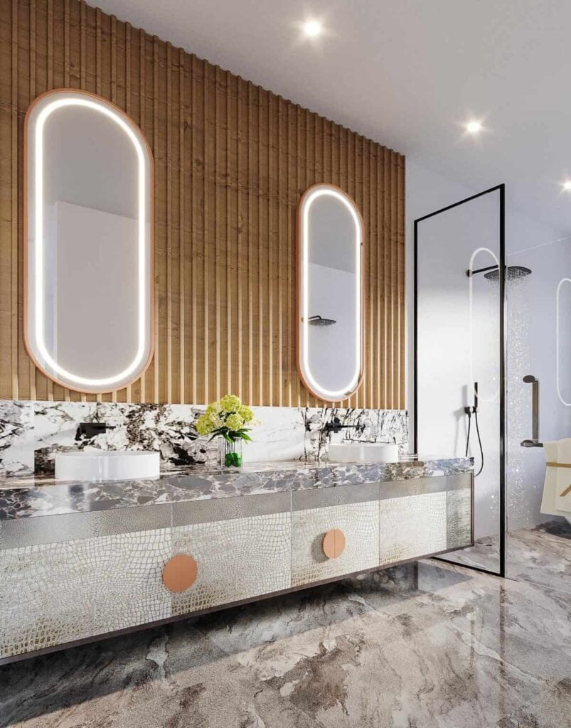 Primary bathroom with an elegant vanity equipped with double vessel sinks and illuminated oval mirrors.