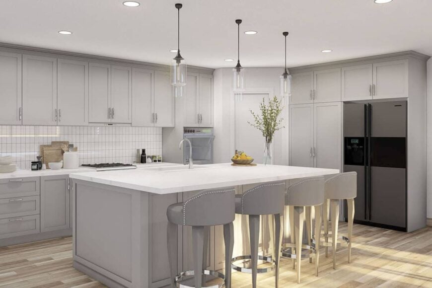 The kitchen is filled with light gray cabinetry, modern appliances, and a large center island lined with round bar stools.