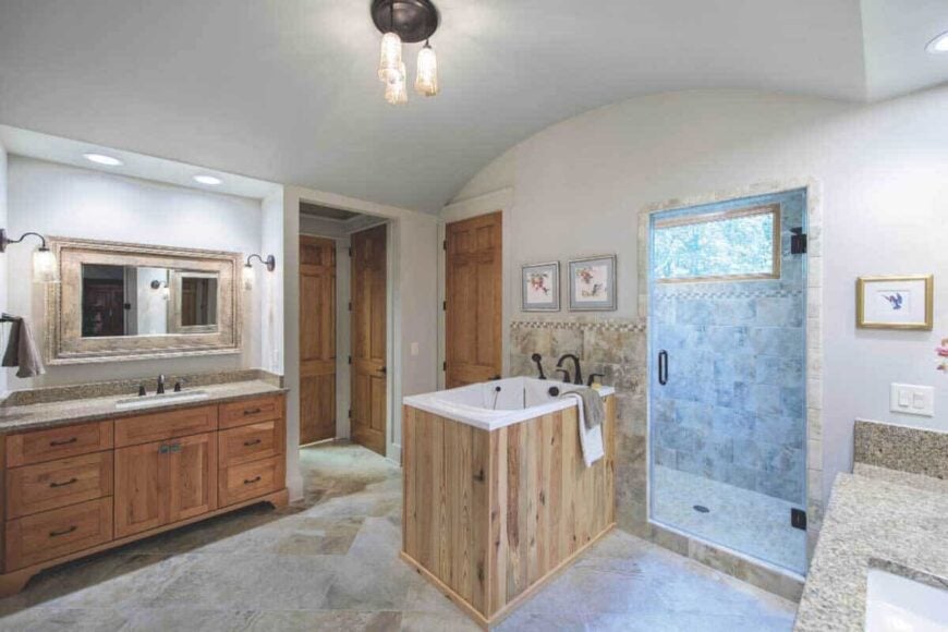 Primary bathroom with a barrel-vaulted ceiling and stark white walls contrasted by wrought iron fixtures.