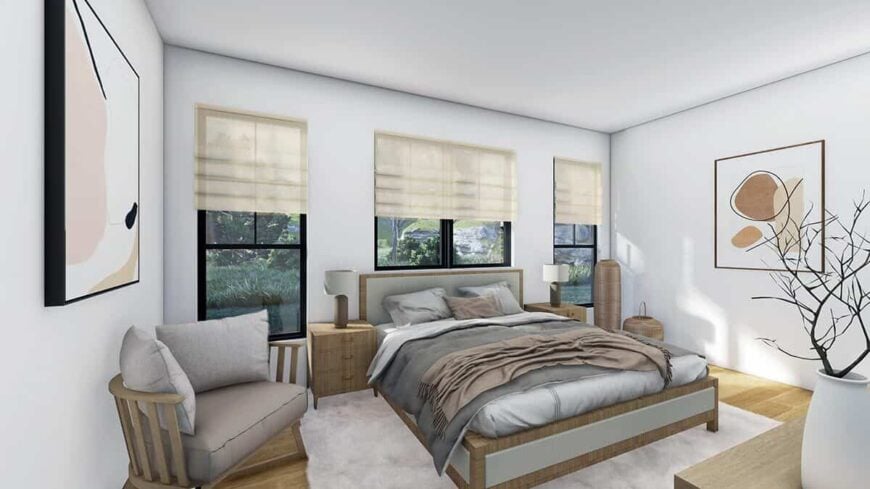 Primary bedroom with a cozy wooden bed, a cushioned armchair, and abstract artworks adorning the pristine white walls.