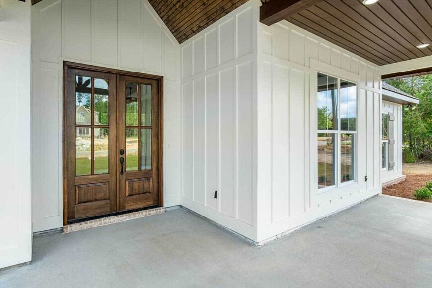 Covered entry with board and batten siding, and a french front door.