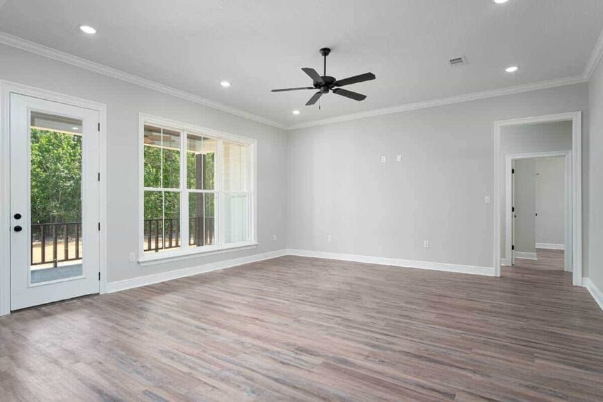The great room includes a trio of windows and a glazed door leading to the back porch.