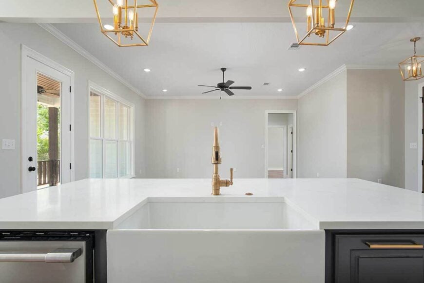 The kitchen island is fitted with a farmhouse sink overlooking the great room.