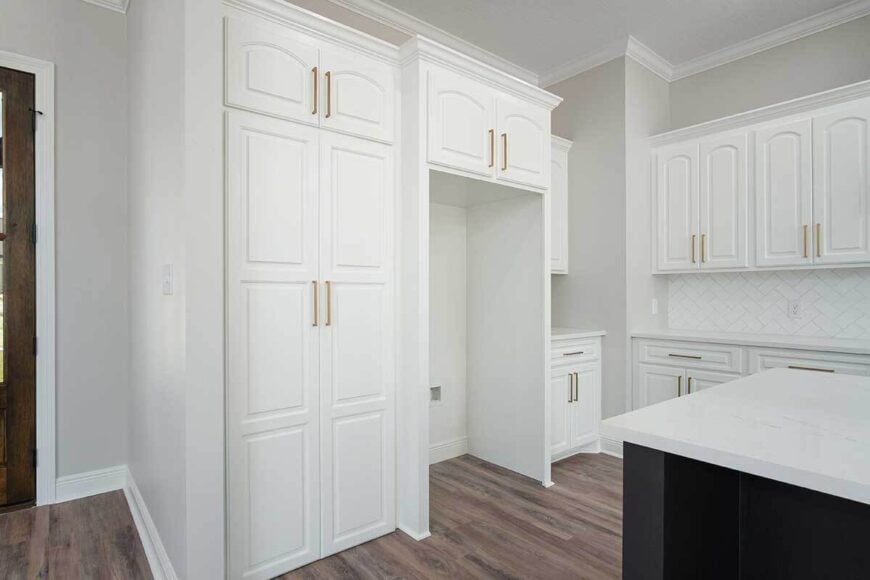 The kitchen includes a walk-in pantry concealed in the cabinet doors.