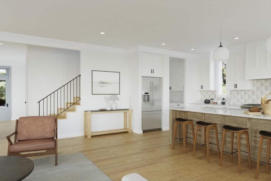 An open layout view of the great room and kitchen with a wooden console table at the middle.