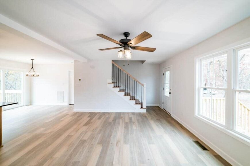 The family room has a ceiling fan and a staircase leading to the upstairs bedrooms.