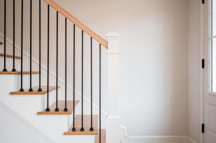 Wrought iron spindles lined with a wooden handrail frame the staircase.