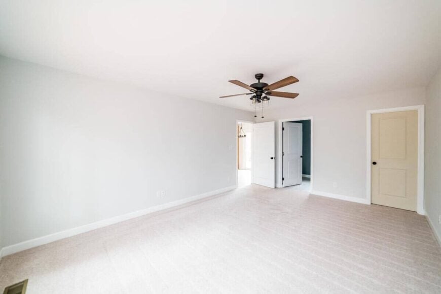 Primary bedroom with a carpeted floor, a walk-in closet, and a private bathroom.