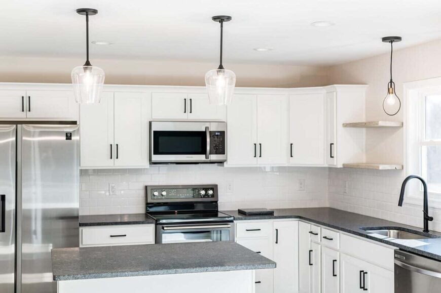 Glass pendant lights top the kitchen island and enhance the bright ambiance.