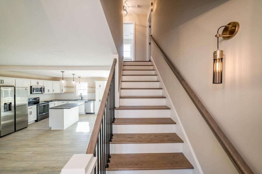 The wooden staircase with white risers and wrought iron spindles lead to the upstairs bedrooms.