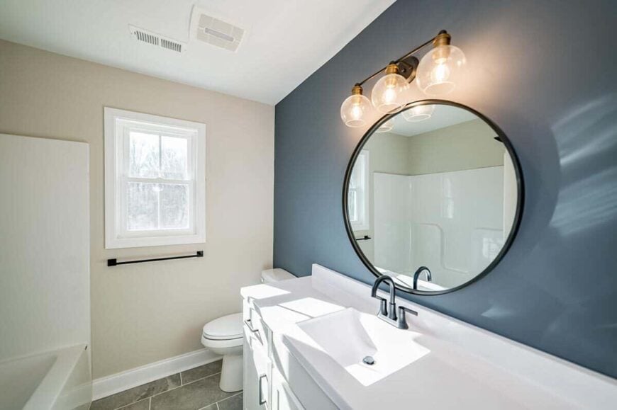 This bathroom includes a white framed window that allows natural light in.