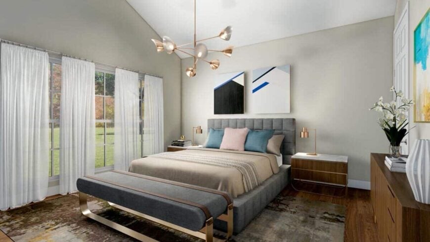 Large windows dressed in sheer curtains bring a light and airy feel into the primary bedroom.