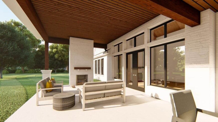 Covered porch with cushioned seats and a stone fireplace under the wood-paneled ceiling.