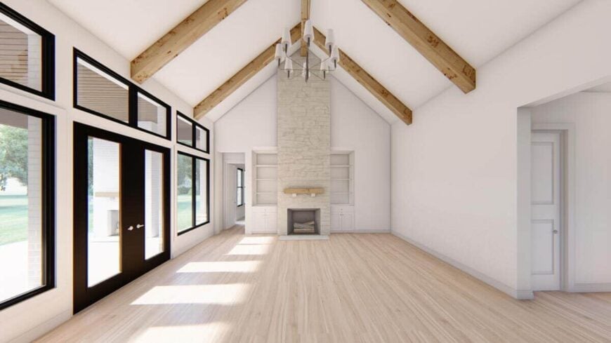 Family room with a stone fireplace, white built-ins, and a cathedral ceiling lined with rustic beams.