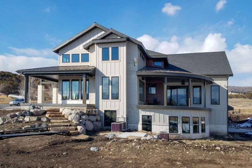Right exterior view with covered porch and deck crowned with metal roofs.
