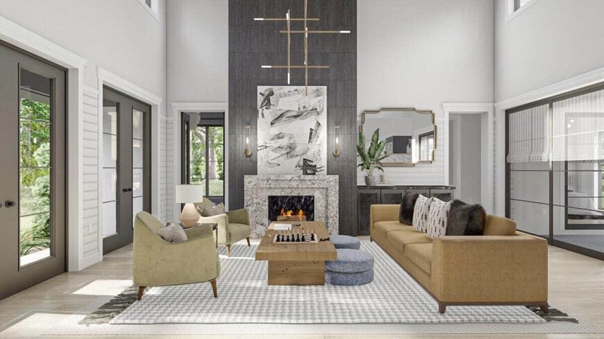 Great room with a two-story ceiling, beige seats, a modern fireplace, and a pair of french doors.