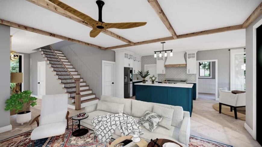 An open layout view of the great room and kitchen. The great room is defined by a beamed ceiling and a vintage area rug.