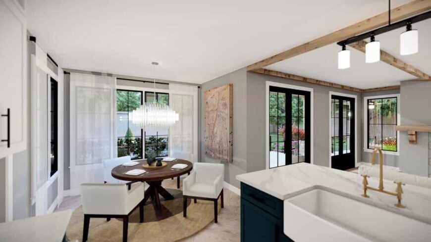 The dining area features a round dining set well-lit by a crystal chandelier.