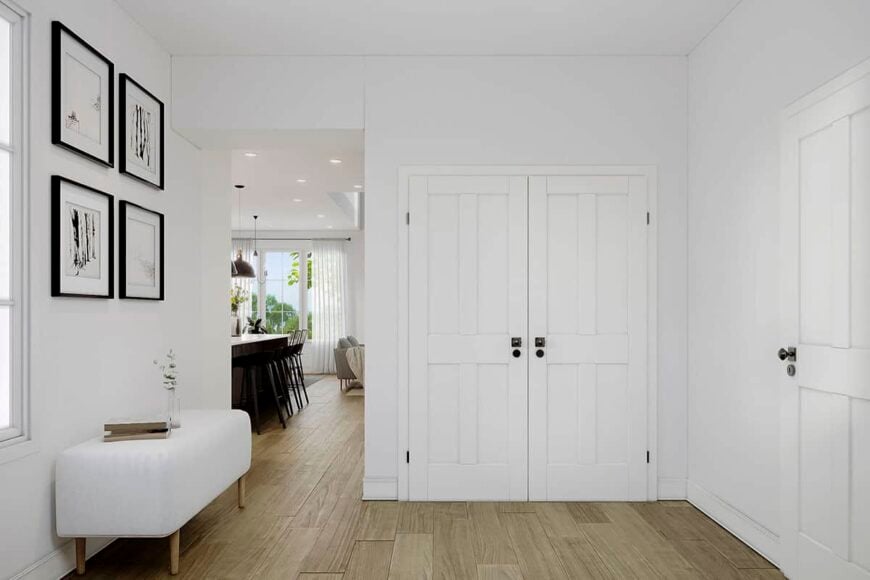 Foyer with a storage closet, framed artworks, and a modern bench that doubles as a table.