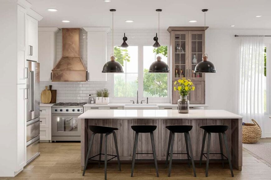 Kitchen with wooden and white cabinets, subway tile backsplash, and a breakfast island lined with round bar stools and dome pendants.
