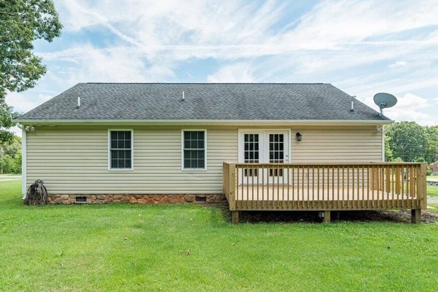 Rear exterior view with a french door and an elevated sun deck.
