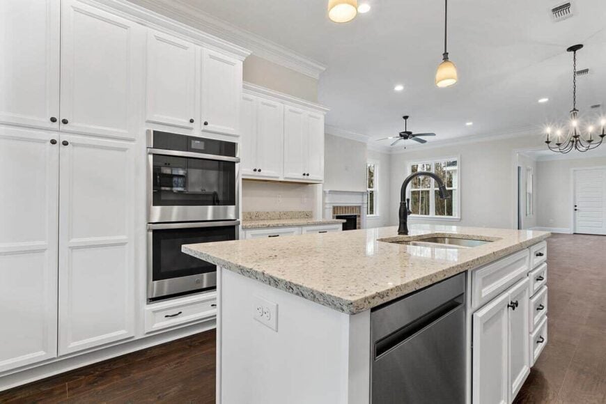 The center island is equipped with double sinks, a dishwasher, and an eating bar.