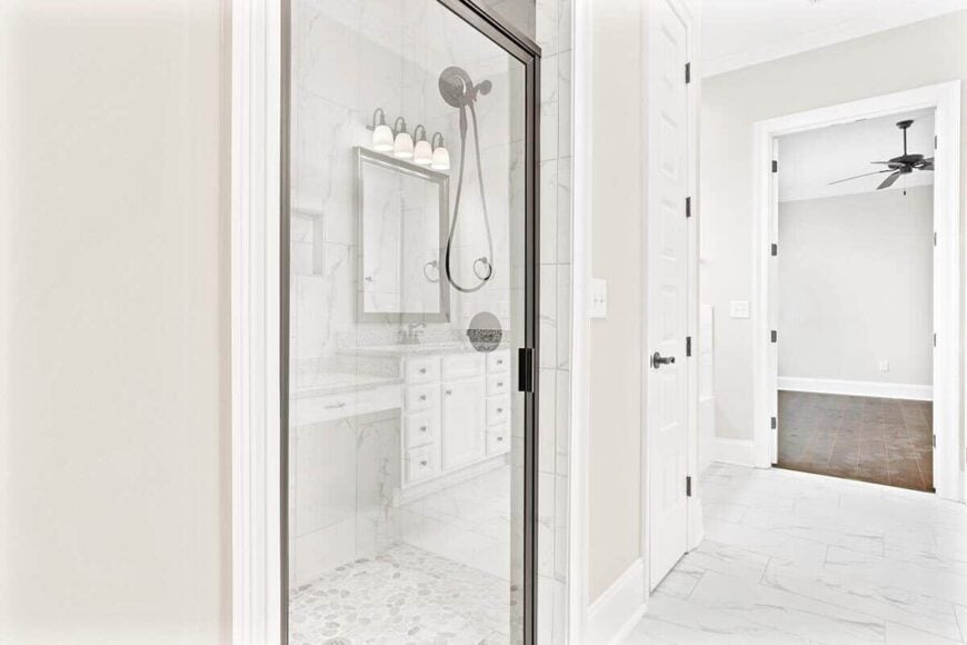 The primary bathroom includes a walk-in shower with wrought iron fixtures and a glass door.