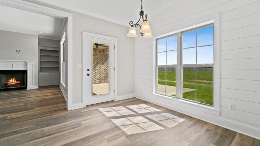 An ornate pendant light along with a glazed door and window brightens the dining area.