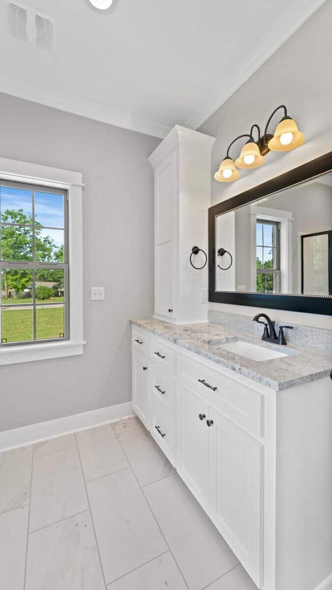 The primary bathroom includes a sink vanity topped with a cabinet and a framed mirror.