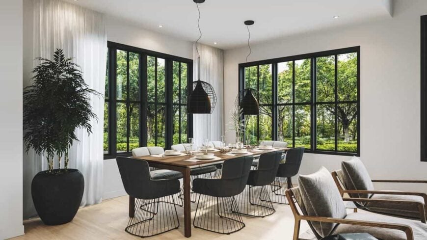 Dining area with modern armchairs and a rectangular dining table topped by industrial pendants.