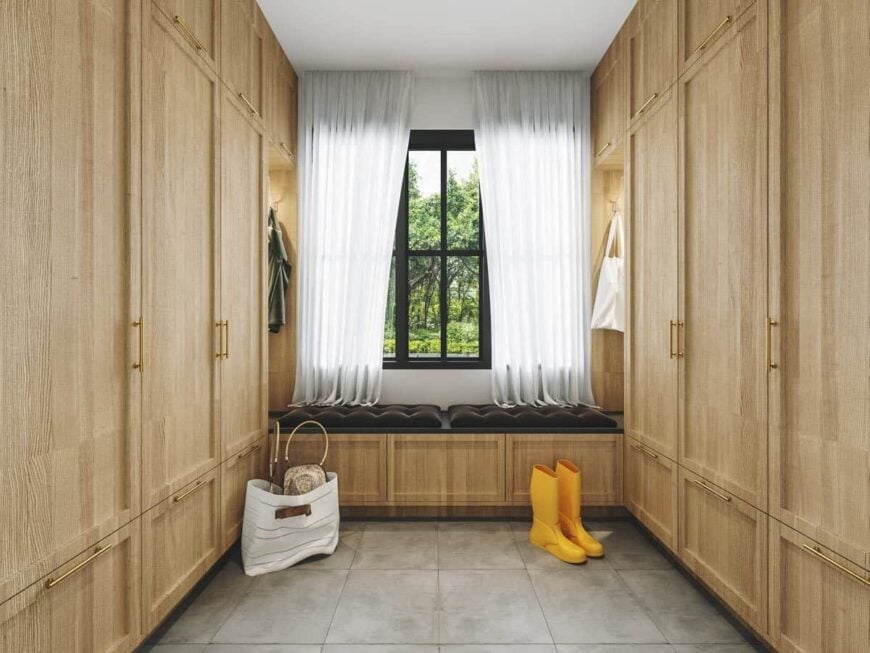 The mudroom features a tufted bench flanked by floor-to-ceiling cabinets.